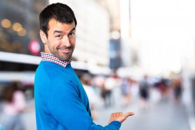 Yakışıklı genç adam bir şey odaklanmamış arka plan üzerinde sunulması