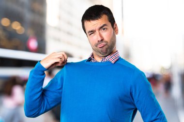 Yakışıklı delikanlı odaklanmamış arka plan üzerinde kendisiyle gurur