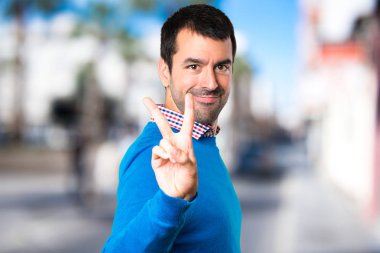 Yakışıklı genç adam yapma zafer jest odaklanmamış adam