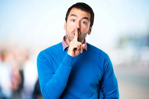 Handsome young man making silence gesture on unfocused backgroun — Stock Photo, Image