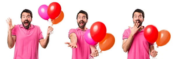 Set von gut aussehenden jungen Mann hält Luftballons und präsentiert etwas — Stockfoto