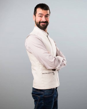 Yakışıklı adam kollarını ile yelek gri arka plan üzerinde çarpı işareti