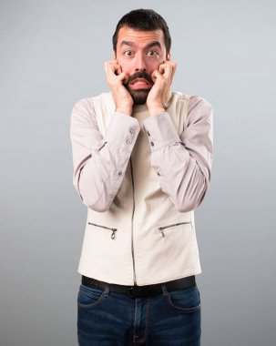 Yelek gri arka plan üzerinde korkmuş yakışıklı adam