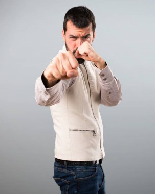 Yelek gri arka plan üzerinde mücadele ile yakışıklı adam