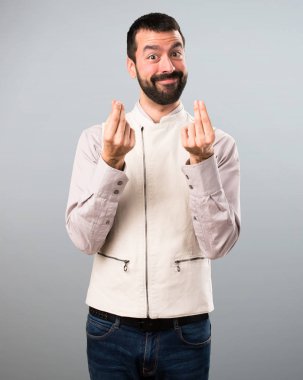 Yelek gri arka plan üzerinde yapma para hareketi ile yakışıklı adam