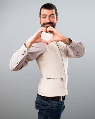 Yakışıklı adam ile yelek gri bac elleri ile bir kalp yapma
