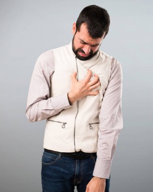 Yelek gri arka plan üzerinde kalp acıyla yakışıklı adam