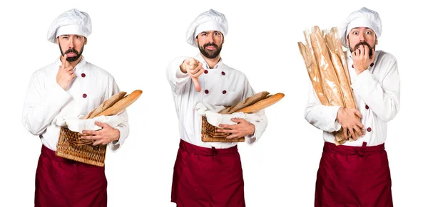 Joven panadero sosteniendo un poco de pan y haciendo mala señal —  Fotos de Stock