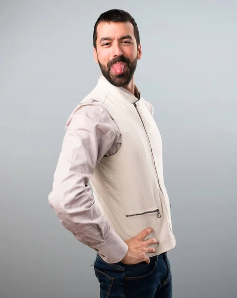 Pohledný muž s vestou vtip na šedém pozadí — Stock fotografie