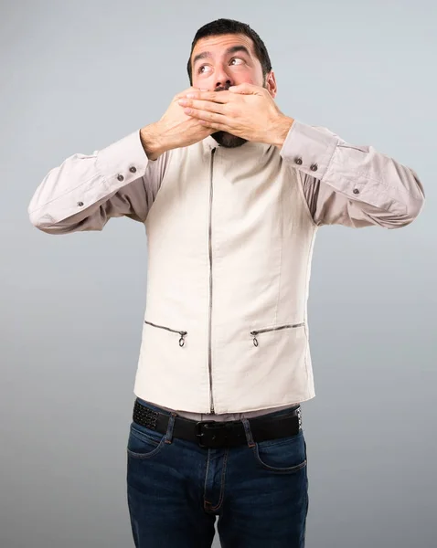 Schöner Mann mit Weste macht Überraschungsgeste auf grauem Hintergrund — Stockfoto