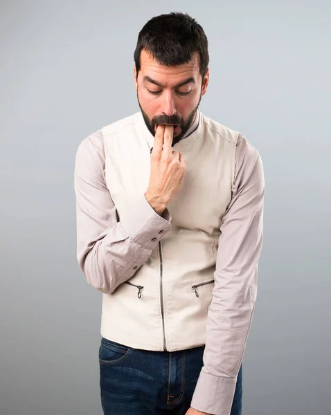 Pohledný muž s vestou, takže zvracení gesto na šedé poza — Stock fotografie