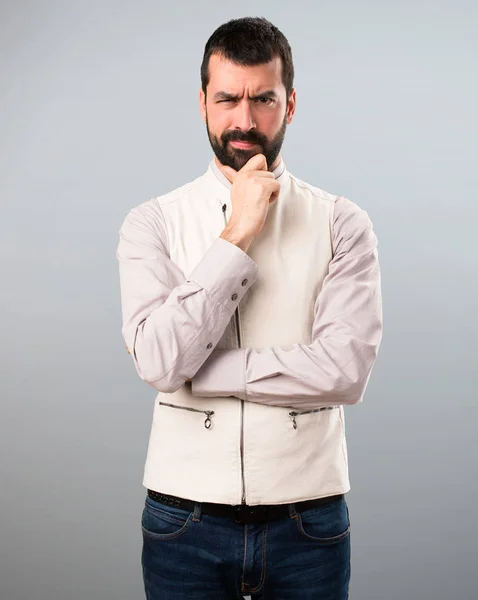 Pohledný muž s myšlením vesta na šedém pozadí — Stock fotografie