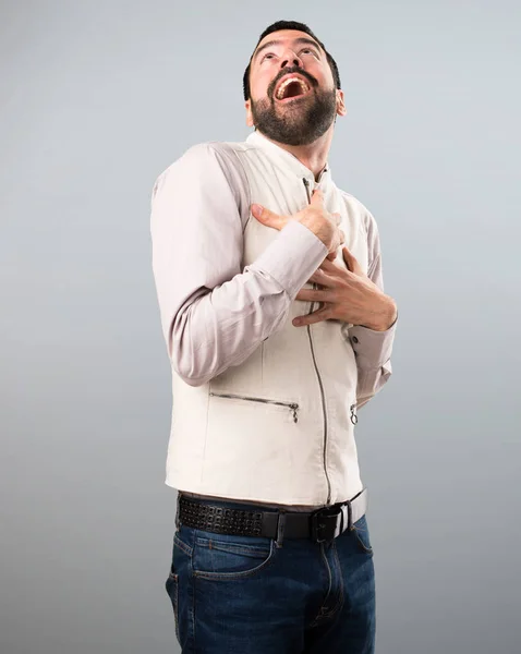 Knappe man met vest opzoeken op grijze achtergrond — Stockfoto