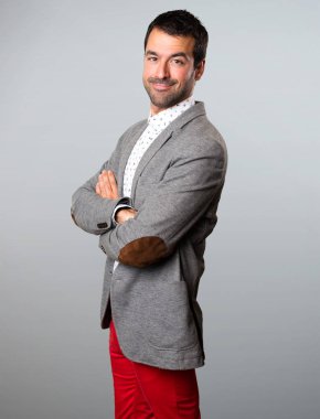 Yakışıklı adam kollarını ile gri arka plan üzerinde çarpı işareti