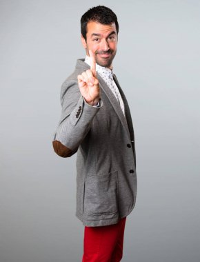 Yakışıklı adam bir gri arka plan üzerinde sayma