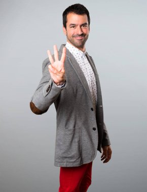 Yakışıklı adam üç gri arka plan üzerinde sayma