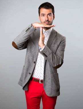 Yakışıklı adam yapma zaman aşımı jest gri arka plan üzerinde