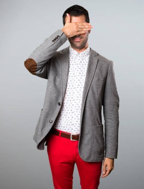 Yakışıklı adam gözlerini gri arka plan üzerine kaplama