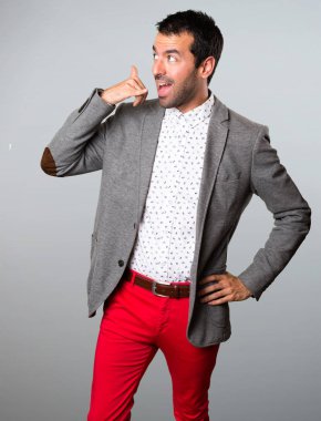 Yakışıklı adam yapım telefon jest gri arka plan üzerinde