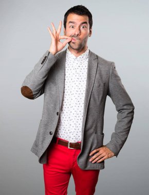 Yakışıklı adam yapma sessizlik jest gri arka plan üzerinde