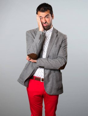 Gri arka plan üzerinde yorgun yakışıklı adam