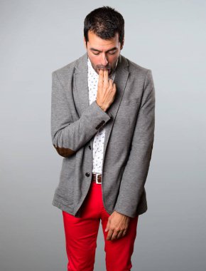 Yakışıklı adam gri arka plan üzerine kusma jest yapma