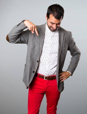 Yakışıklı adam gri arka plan üzerinde aşağı dönük