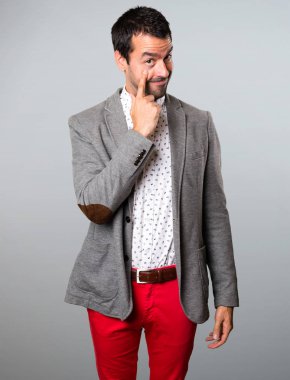 Yakışıklı adam bir şey gri arka plan üzerinde gösterilen