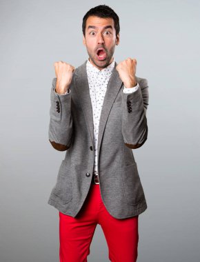 Gri arka plan üzerinde şanslı yakışıklı adam