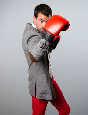 Gri arka plan üzerinde boks eldivenli yakışıklı adam