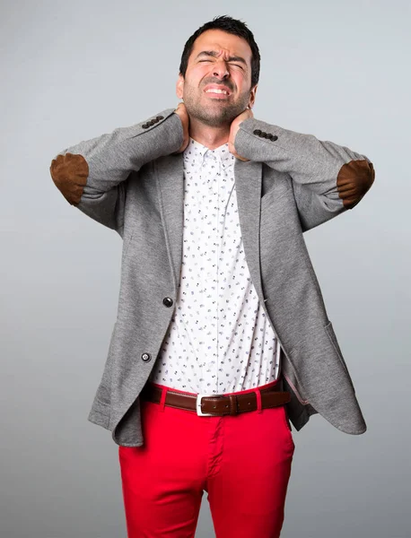 Hombre guapo con dolor de cuello sobre fondo gris — Foto de Stock