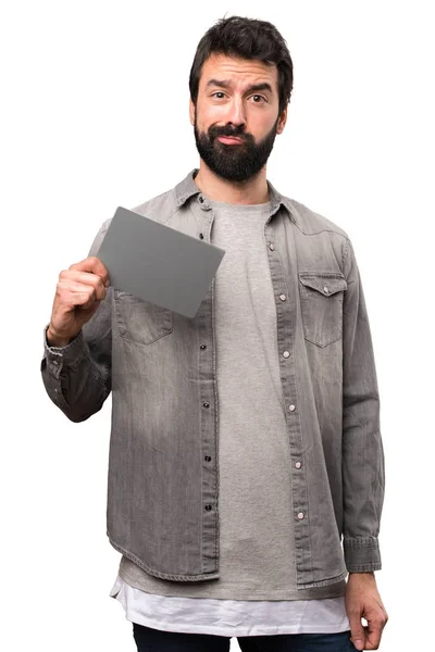 Hombre guapo con barba sosteniendo una tarjeta gris sobre fondo blanco — Foto de Stock