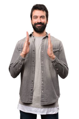 Bir şey beyaz arka plan üzerinde tutan sakallı yakışıklı adam