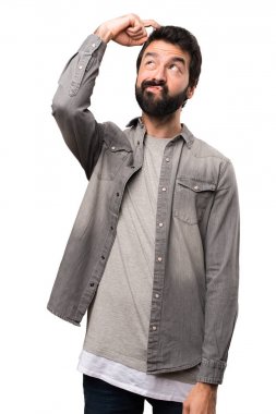 Beyaz arka plan üzerinde şüpheleri sakallı yakışıklı adam