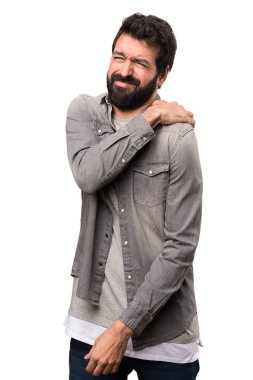 Beyaz arka plan üzerinde omuz ağrısı ile sakallı yakışıklı adam