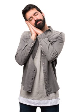 Beyaz arka plan üzerinde sakal yapma uyku hareketi ile yakışıklı adam