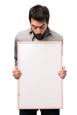 Boş bir afiş üzerinde beyaz backgr tutan sakallı yakışıklı adam