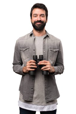 Beyaz arka plan üzerinde dürbün ile sakallı yakışıklı adam