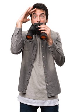 Beyaz arka plan üzerinde dürbün ile sakallı yakışıklı adam