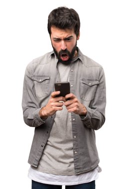 Beyaz arka plan üzerinde konuşmak için telefon sakallı yakışıklı adam