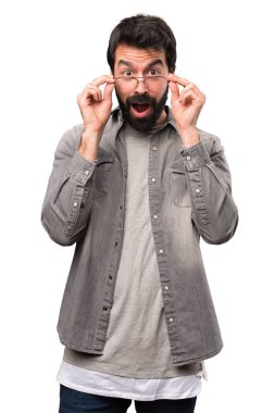 Şaşırmış yakışıklı adam sakallı ve beyaz arka gözlüklerle