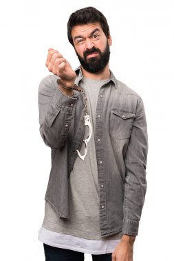 Yakışıklı adam sakallı ve beyaz arka plan üzerinde kelepçe ile