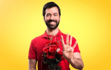 Yakışıklı adam dört Sarı zemin üzerine sayma çiçek tutan