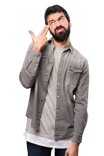 Hombre guapo con barba haciendo un gesto suicida en el fondo blanco — Foto de Stock