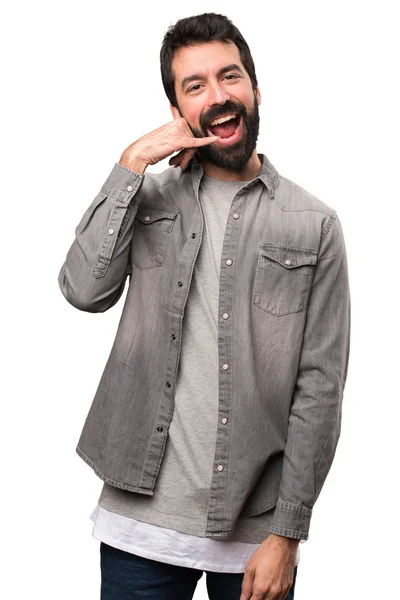Красивый мужчина с бородой делает телефонный жест на белом фоне — стоковое фото