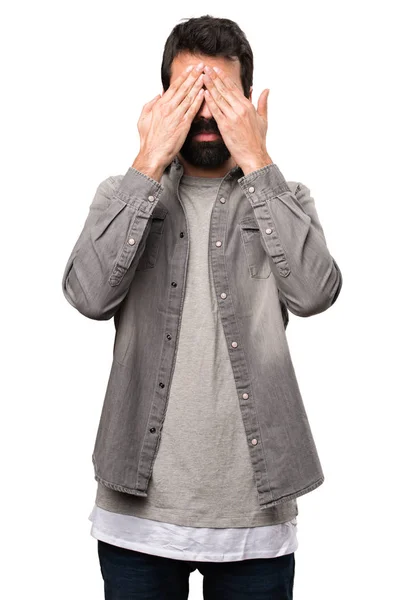 Handsome man with beard covering his eyes on white background — Stock Photo, Image