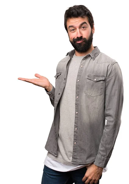 Przystojny mężczyzna z brodą trzyma coś na białym tle — Zdjęcie stockowe