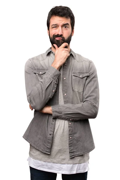 Bonito homem com barba pensando no fundo branco — Fotografia de Stock