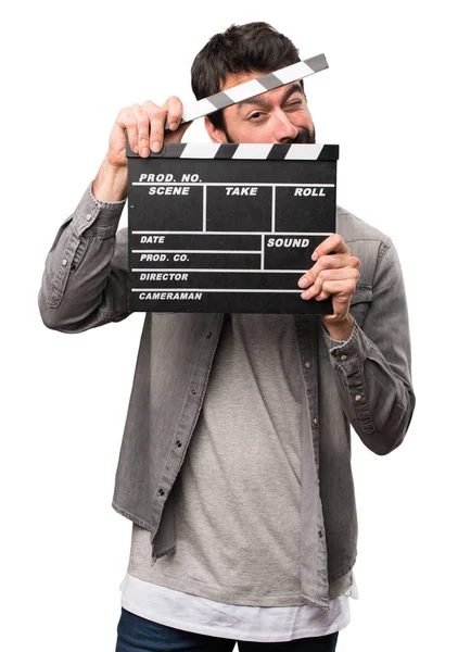 Hombre guapo con barba sosteniendo una tabla de aplausos en el fondo blanco —  Fotos de Stock