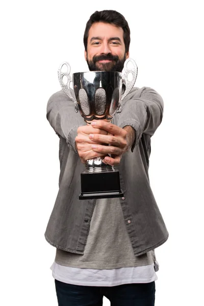 Hombre guapo con barba sosteniendo un trofeo sobre fondo blanco —  Fotos de Stock